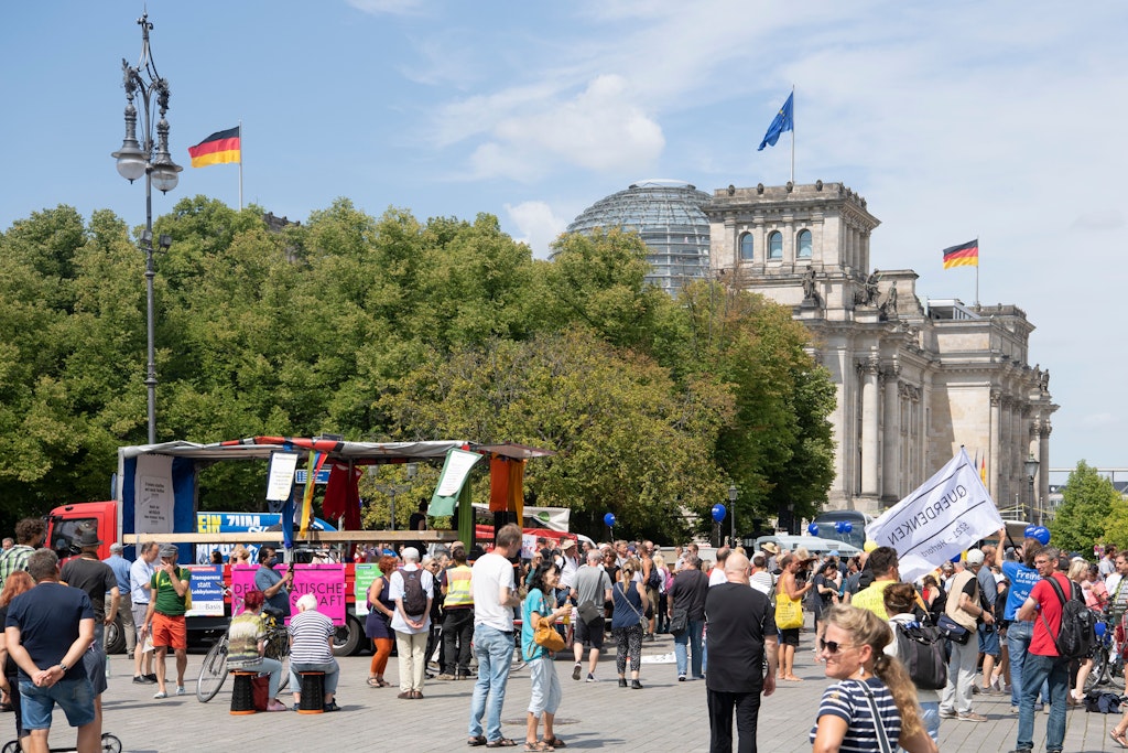 Teilnehmer der Demonstration "Uneingeschränkte Wiederherstellung sämtlicher Grundrechte" stehen unweit des Reichstages in Berlin. Der Protest richtet sich gegen die Corona-Schutzmaßnahmen der Länder und des Bundes.