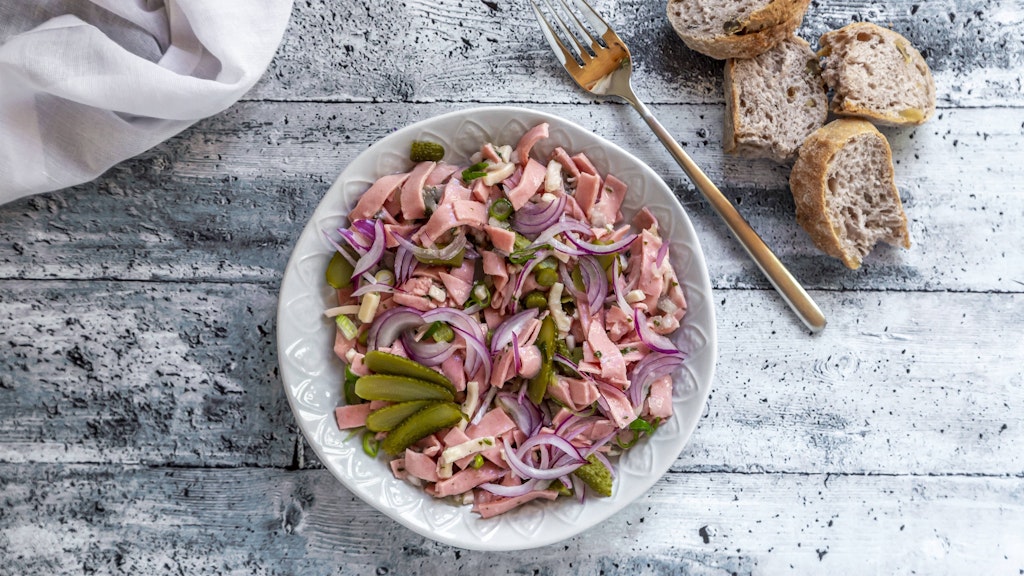 Wurstsalat ist ein echter Feinkost-Klassiker... und schmeckt auch bei Hitze gut. Wer die Zwiebeln etwas grober mag, kann sie auch in Streifen schneiden - das Rezept ist variabel.
