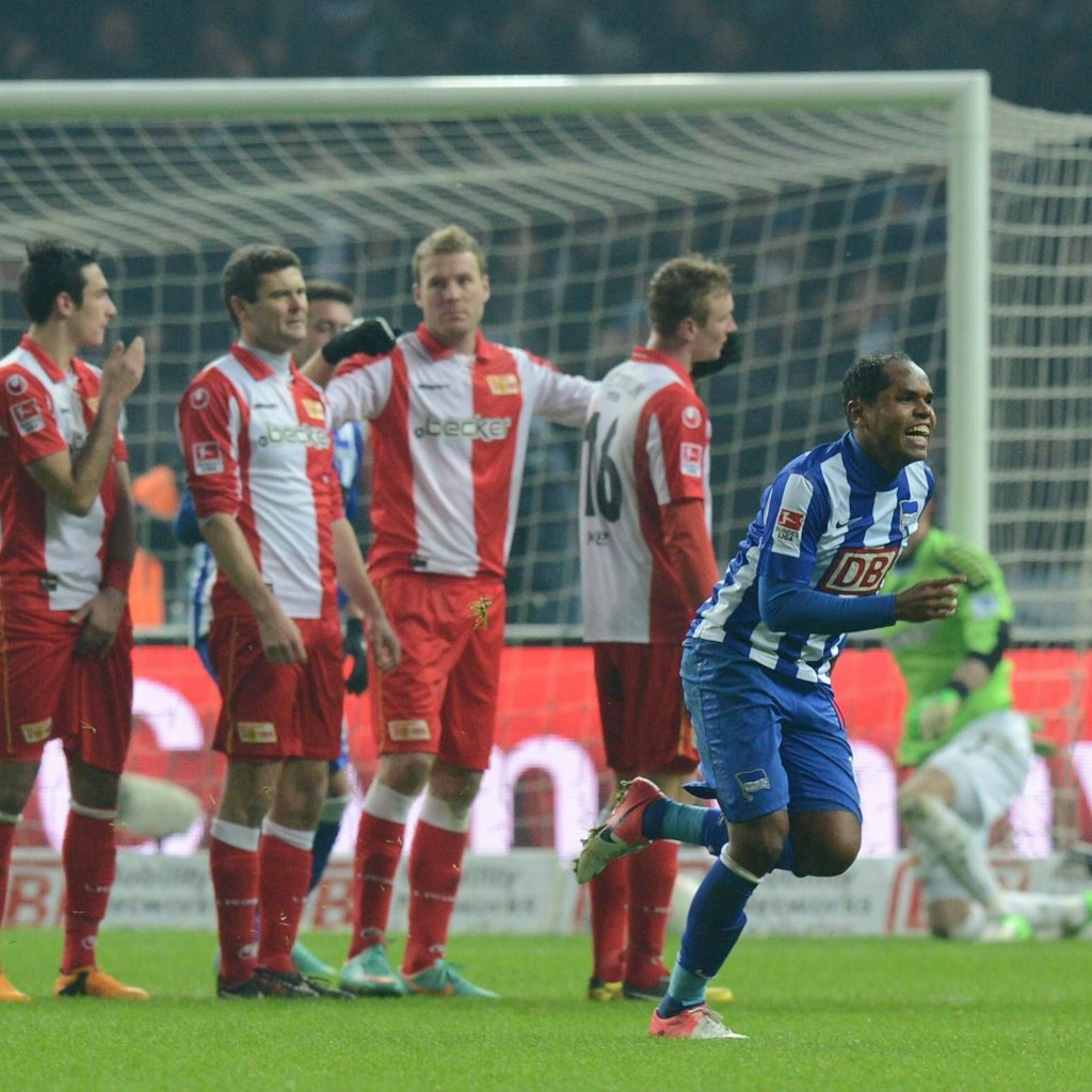 Lange Gesichter bei den Union-Kickern, Herthas Ronny dreht jubelnd ab nach seinem Freistoßtreffer.