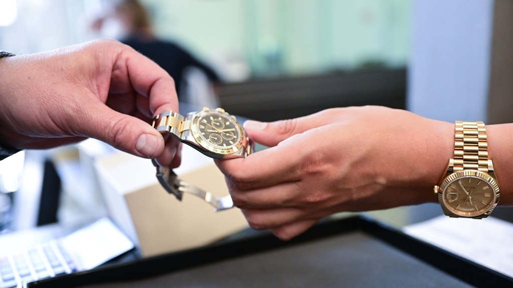 Ein Kunde reicht eine Rolex über den Tisch. 19.000 Euro bekommt er dafür.