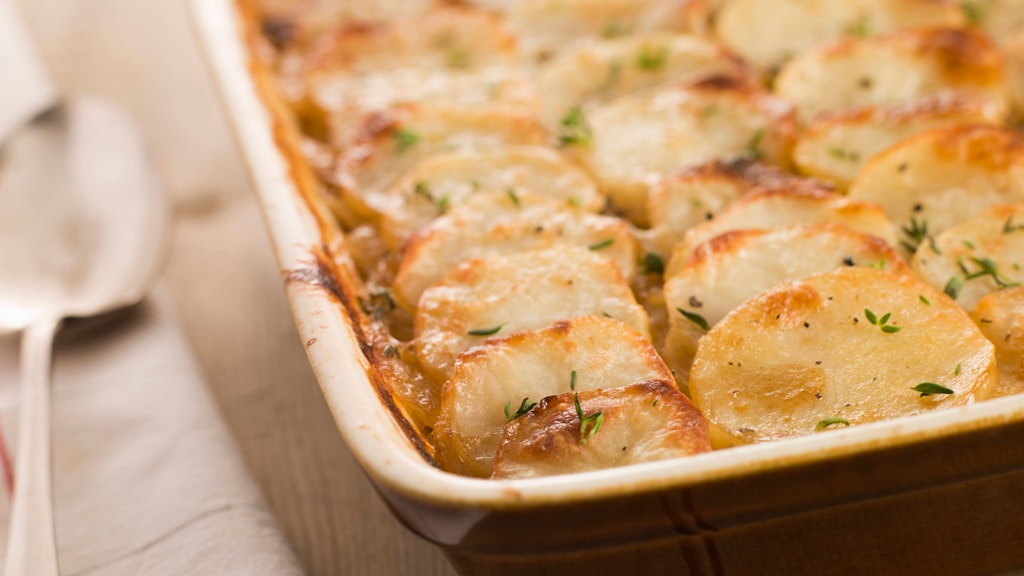 Für das Kartoffelgratin werden Kartoffeln und Knoblauch wie Dachziegel geschichtet.