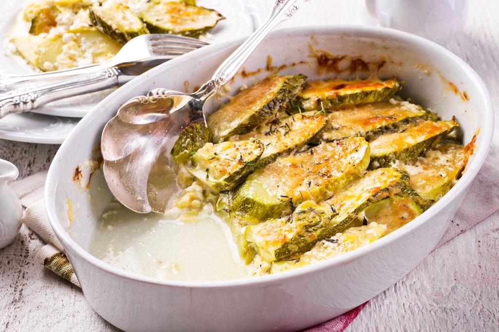 Überbackene Zucchini-Scheiben kann man auf dem Backblech oder in einer Auflaufform zubereiten. Das Rezept ist ganz simpel.