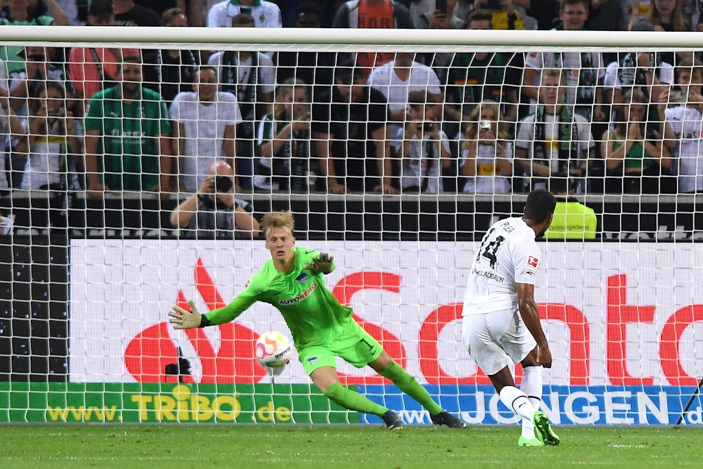 Herthas Keeper Christensen ahnt die richtige Ecke beim Handelfer, doch Gladbachs Plea trifft zum 1:0.