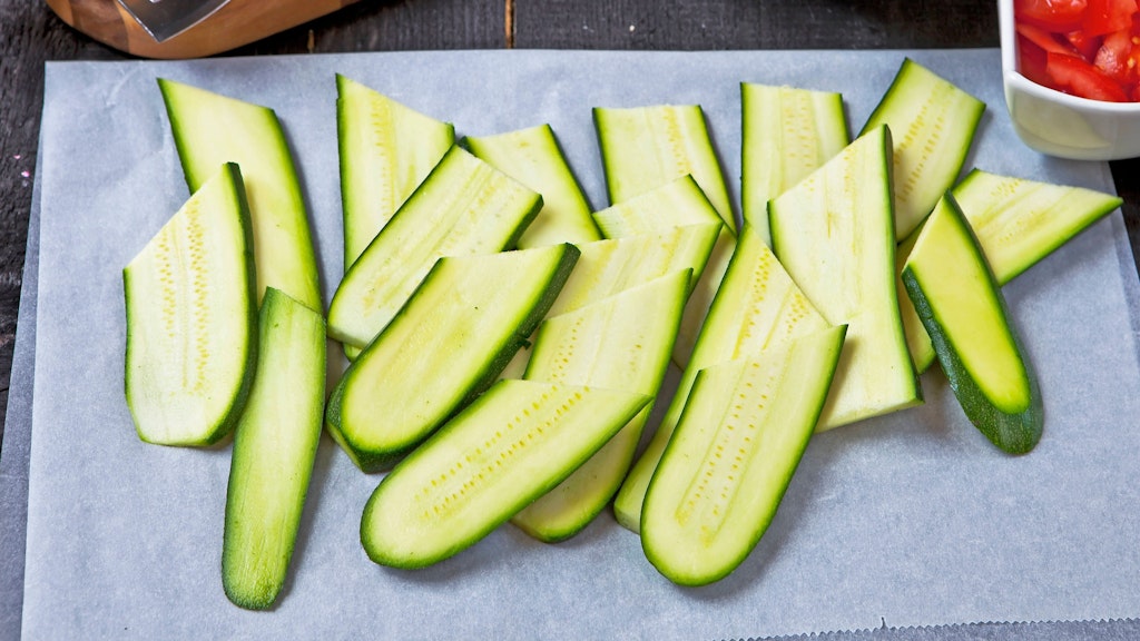 Laut Rezept für die Zucchini-Schnitzel schneiden Sie das Gemüsen am besten längst in Scheiben.