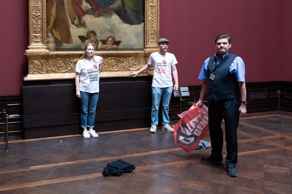 Zwei Mitglieder der Gruppe „Letzte Generation“ haben sich am Gemälde „Sixtinische Madonna“ von Raffael festgeklebt. Dann gab es ein Foto samt Wachmann …