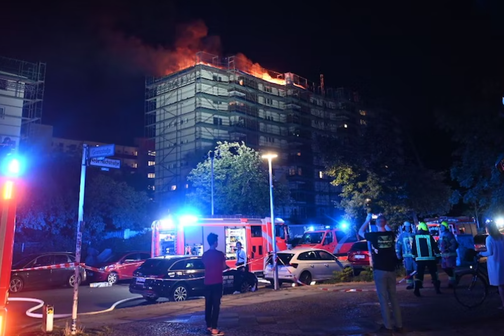 Löschwagen stehen vor einem Mietshaus an der Neuen Hochstraße in Gesundbrunnen. Auf dem Dach des eingerüsteten Hauses war ein Feuer ausgebrochen.