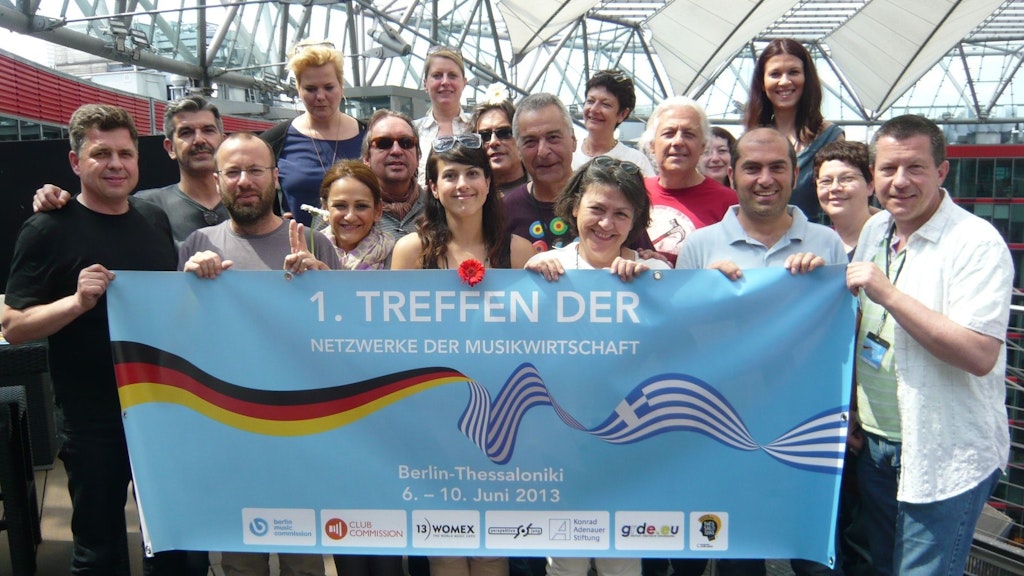 Gut gelauntes Treffen in Thessaloniki: Goiny (r.) unter anderem mit der damaligen Kultur-Stadträtin Elli Chrysidou (über dem Wort "DER") und Sören Birke (l.), Betreiber der Kulturbrauerei.