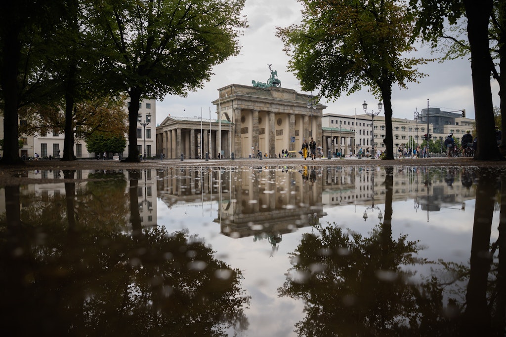 Das Brandenburger Tor spiegelt sich nach einem Regenschauer am Freitagnachmittag in einer Pfütze. 