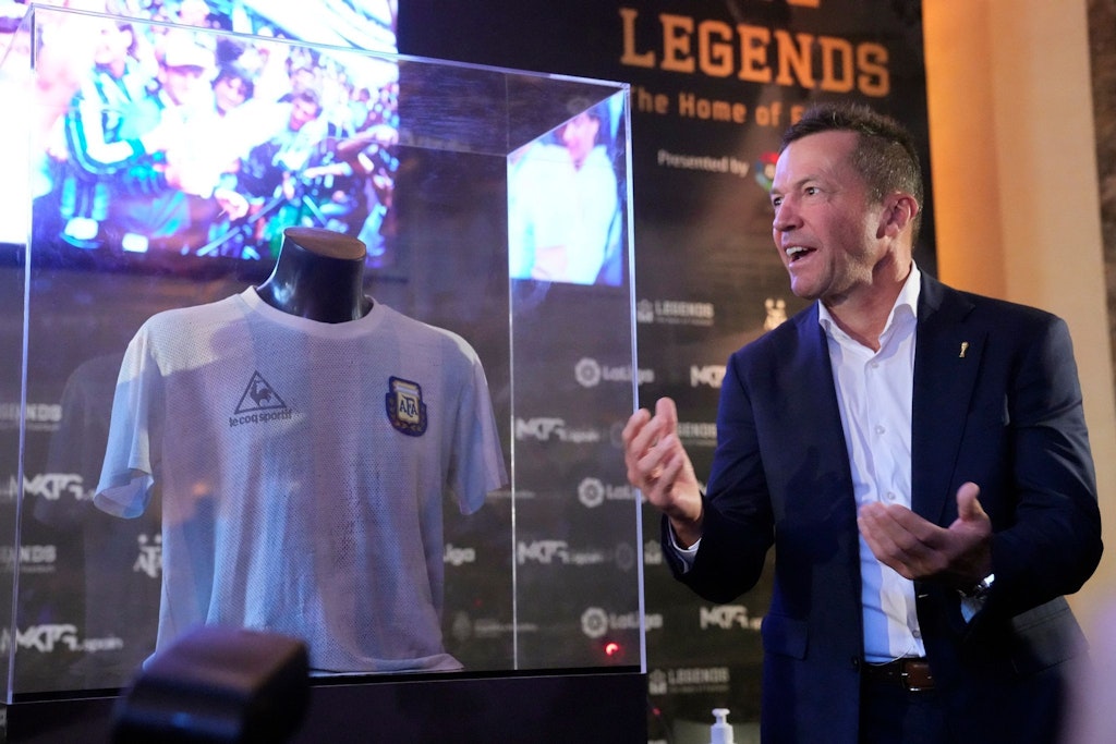 Lothar Matthäus neben einer Vitrine, in der sich das Trikot von Diego Maradona befindet.