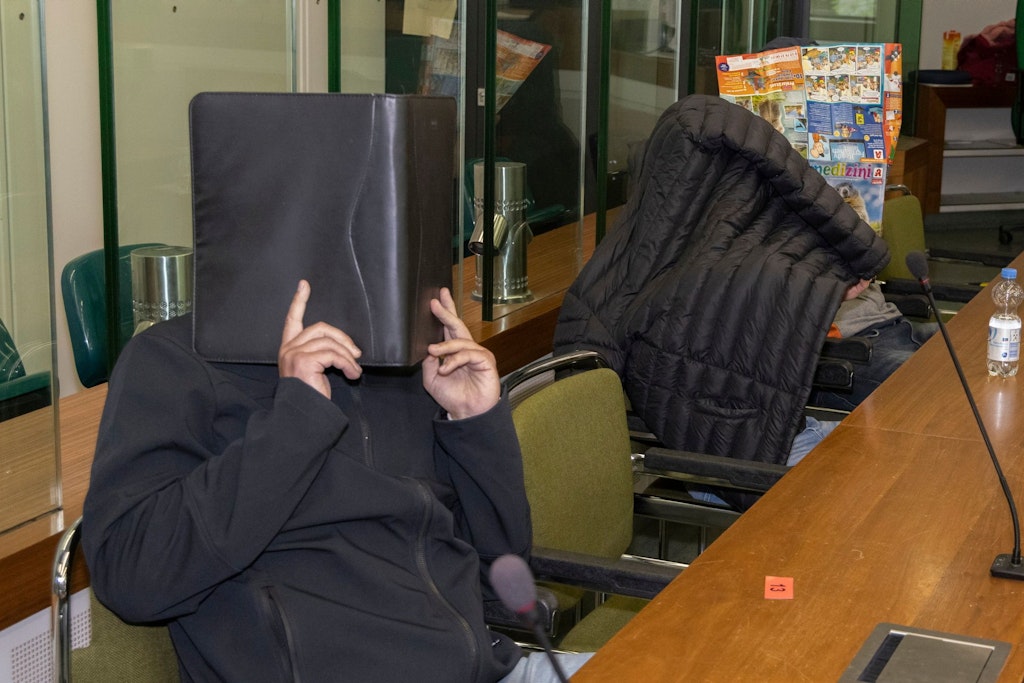 Die Angeklagten verstecken im Gerichtssaal ihre Gesichter.