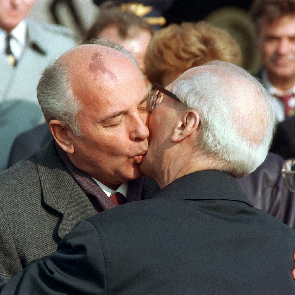 Der sowjetische Staats- und Parteichef Michail Gorbatschow (l) wird nach seiner Ankunft zu den Feierlichkeiten zum 40jährigen Staatsjubiläum der DDR am 6. Oktober 1989 in Ost-Berlin von dem Staatsratsvorsitzenden Erich Honecker mit dem traditionellen Bruderkuss willkommen geheißen. 