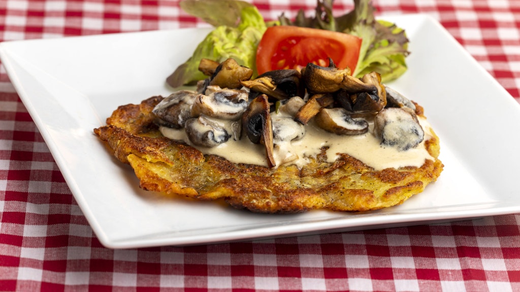 Kartoffelpuffer sind auch herzhaft ein Genuss: Mit Champignons in Sahnesoße sind Reibekuchen ein Hit für Liebhaber der deftigen Küche.