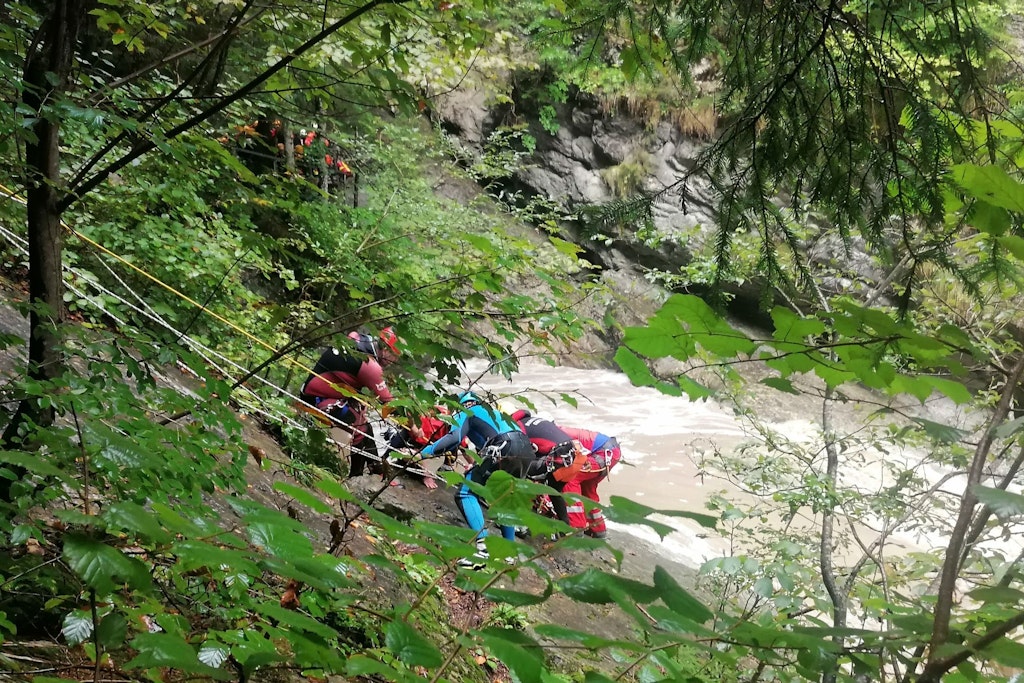 Rettungskräfte suchen an der Unglücksstelle an einem Steilhang am Ufer der Starzlach.