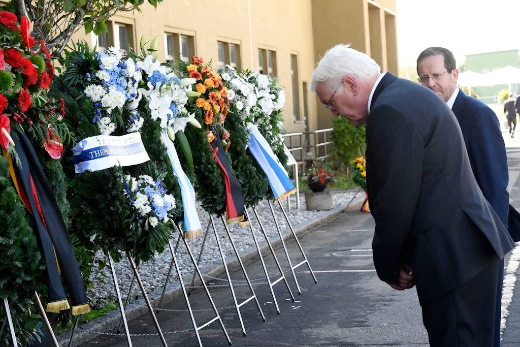 Bundespräsident Frank-Walter Steinmeier verneigt sich inFürstenfeldbruck vor Kränzen, neben ihm steht Israels Präsident Isaac Herzog.