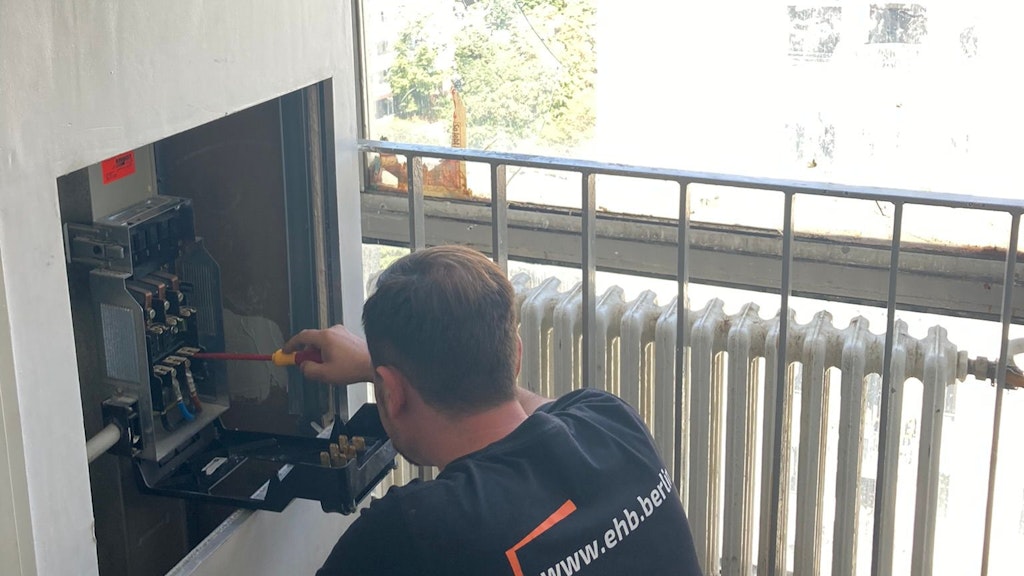 Ein Elektriker bei der Arbeit: 119 der 400 Wohnungen waren wegen des Wasserschadens ohne Strom. Auch das Flurfenster hatte der Täter eingeschlagen.
