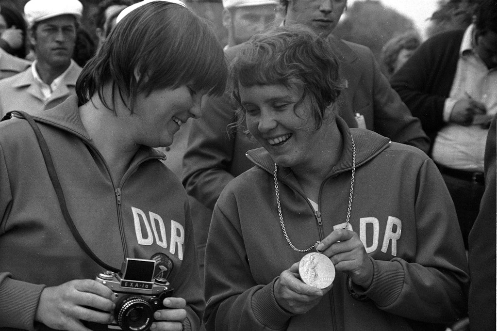 Olympiasiegerin Angelika Bahmann (r.) zeigt Sybille Boedecker, die damals Elfte wurde, ihre Goldmedaille.