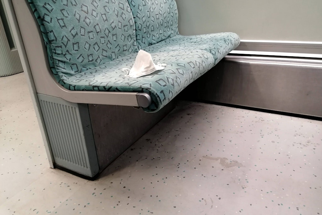 Eine FFP2-Maske liegt auf einem Berliner S-Bahn-Sitz. Eigentlich gehört sie auf Mund und Nase.