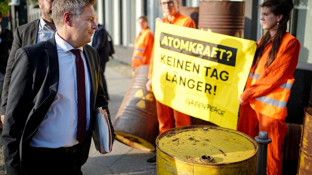 Bundeswirtschaftsminister Robert Habeck passiert auf dem Weg zur Pressekonferenz zu den Ergebnissen des Stresstests mehrere Greenpeace-Protestler. 