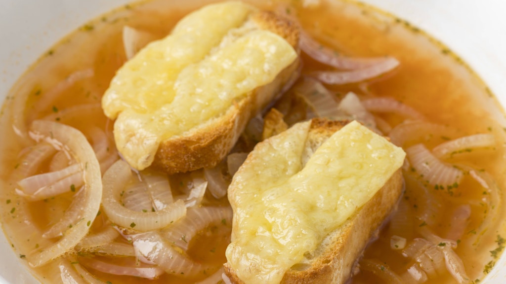 Mit etwas überbackenem Baguette schmeckt die Zwiebelsuppe besonders gut.