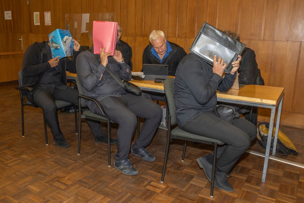 Die Herren vom Kfz-Servicedienst verstecken ihre Gesichter. Mit einem „Boni“ für den Beamten kamen sie schneller an die Zulassungen.