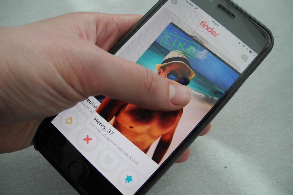 Ein Nutzer hält ein Smartphone, auf dem die App Tinder läuft, in der Hand. Die Dating-App startete am 12. September vor zehn Jahren.