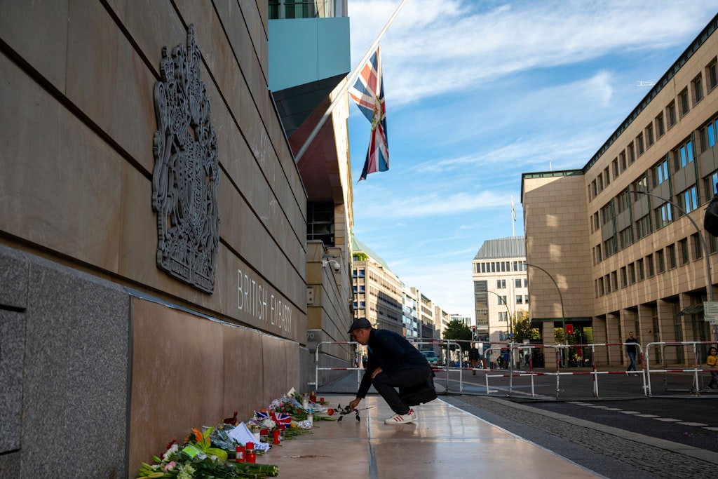 Vor der Britischen Botschaft in Berlin legt ein Mann nach dem Tod von Queen Elizabeth II. eine Blume nieder. 