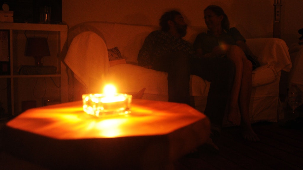 Ein Paar sitzt während eines Stromausfalls bei Kerzenschein in einer Wohnung in Hannover. 