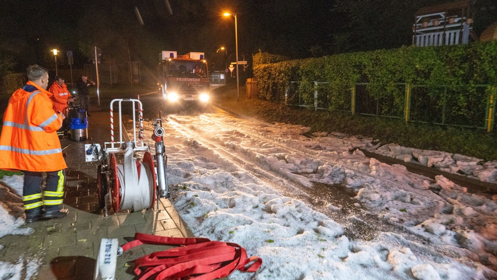 Hagelkörner liegen auf einer Straße in Stralsund. Keller und Wohnungen wurden durch Regen geflutet.