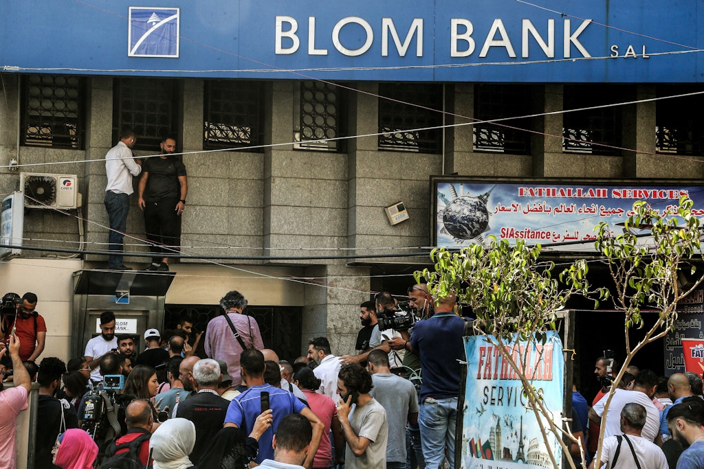 Libanesische Aktivisten versammeln sich vor einer örtlichen Bank, nachdem ein Mann die Filiale gestürmt hat, um an seine Einlagen zu gelangen. Zum siebten Mal innerhalb einer Woche ist im Libanon eine Bank überfallen worden - die Täter forderten dabei ihr eigenes Geld. 
