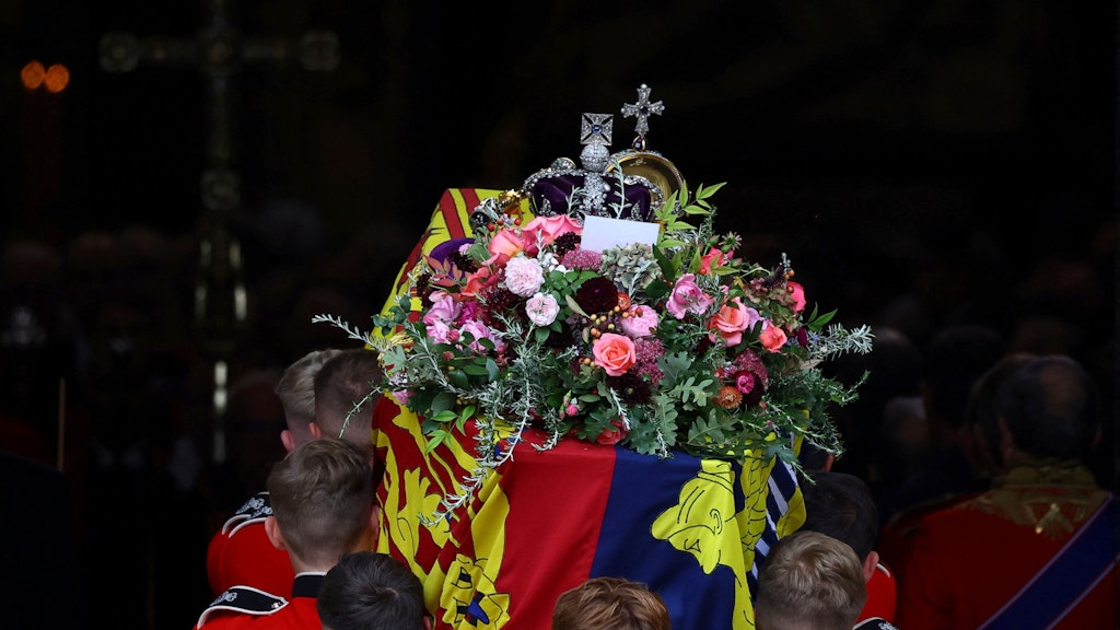 Eine kleiner Umschlag steckt in den Blumen auf dem Sarg der Queen.