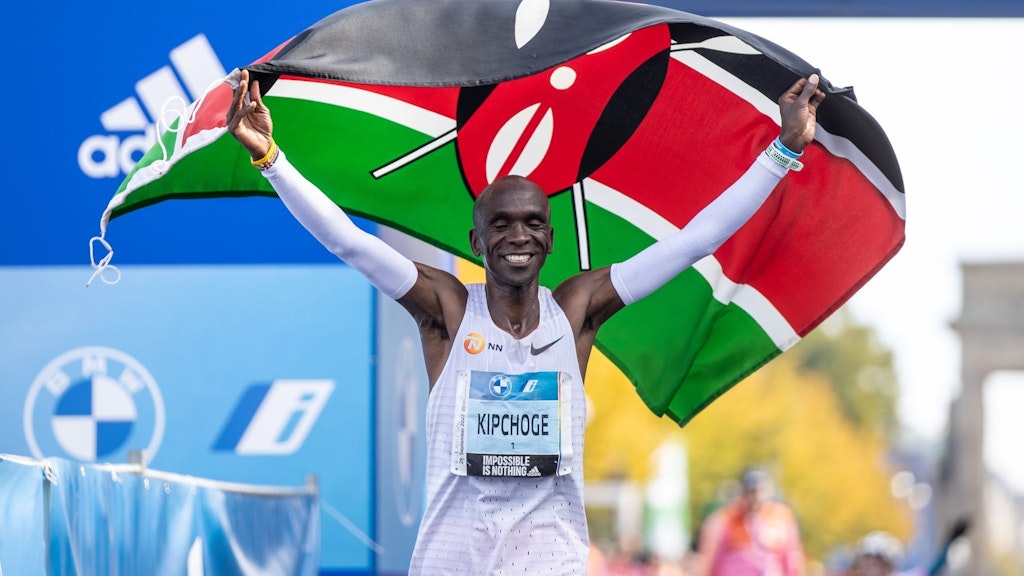 Eliud Kipchoge jubelt mit der kenianischen Flagge. Er lief den Marathon in Weltrekordzeit.