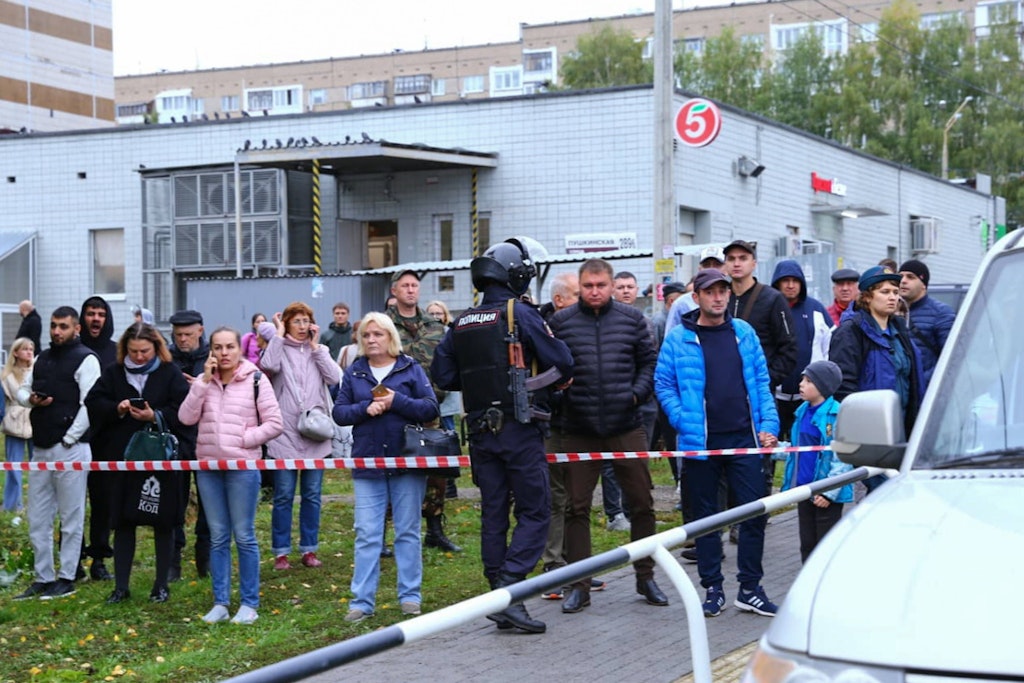 Menschen stehen vor der Schule in Ischewsk und warten auf Nachrichten von ihren Angehörigen.