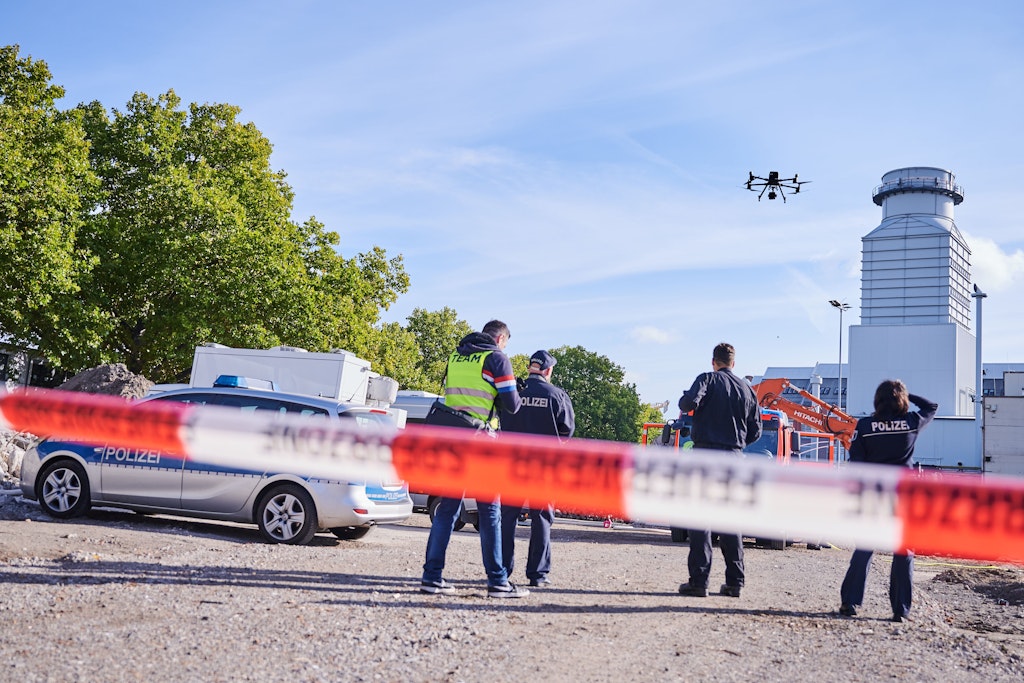 Polizisten stehen hinter einer Absperrung auf der Baustelle in Moabit, wo eine Weltkriegsbombe gefunden wurde.