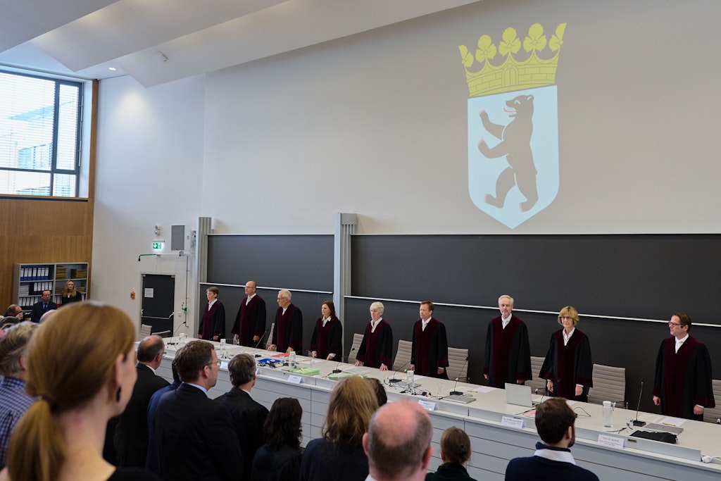 Die Richter des Verfassungsgerichtshofes Ulrike Lembke (v. l.), Sönke Hilbrans, Jürgen Kipp, Sabrina Schönrock, Ludgera Selting (Präsidentin), Robert Wolfgang Seegmüller, Ahmet Kurt Alagün, Margarete Gräfin von Galen und Christian Burholt stehen vor Beginn der Verhandlungen in einem Hörsaal der Freien Universität in Dahlem.