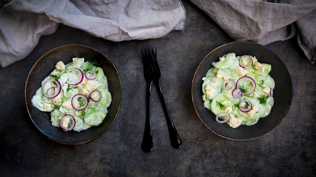 Wer mag, kann zum Gurkensalat mit Feta auch noch rote Zwiebeln geben, dann wird er noch würziger.