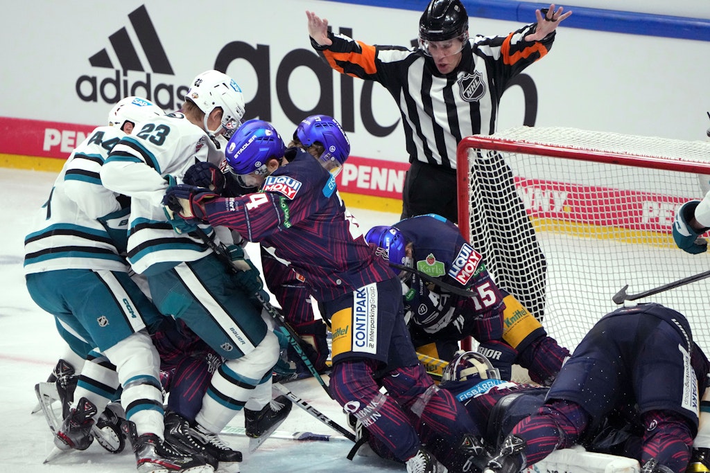 Berlin: Eishockey: NHL Global Series, Eisbären Berlin - San Jose Sharks. Berlins Marco Baßler (M) schiebt San Joses Marc-Edouard Vlasic (l) und Oskar Lindblom (2.vl) vom Tor weg. 