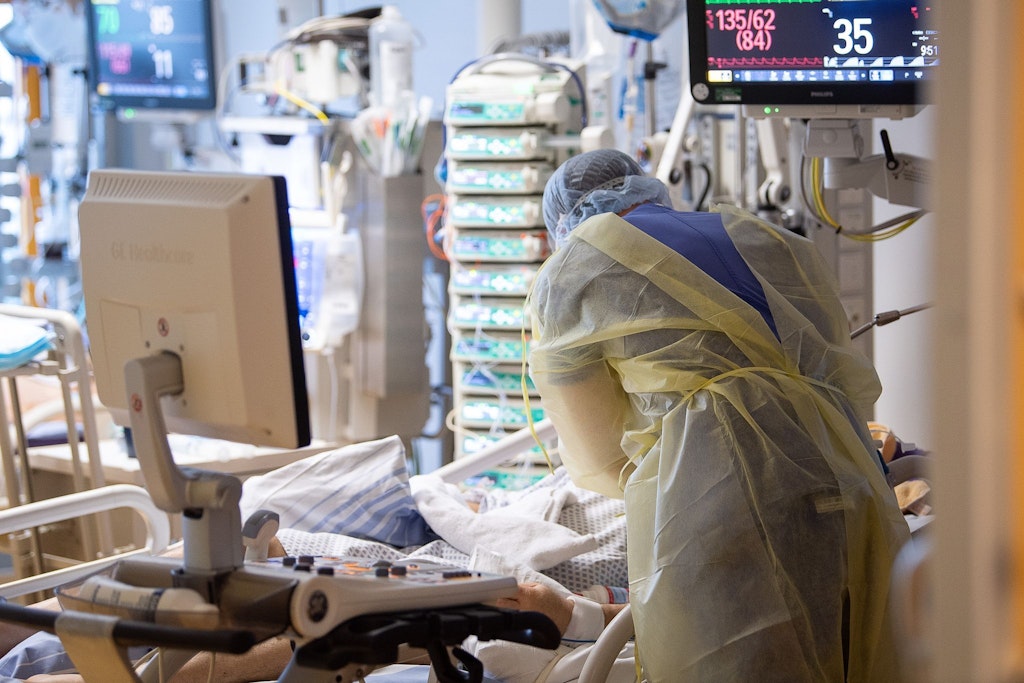 Ein Intensivpfleger auf der Intensivstation eines Krankenhauses neben einem Covid-19-Patienten.