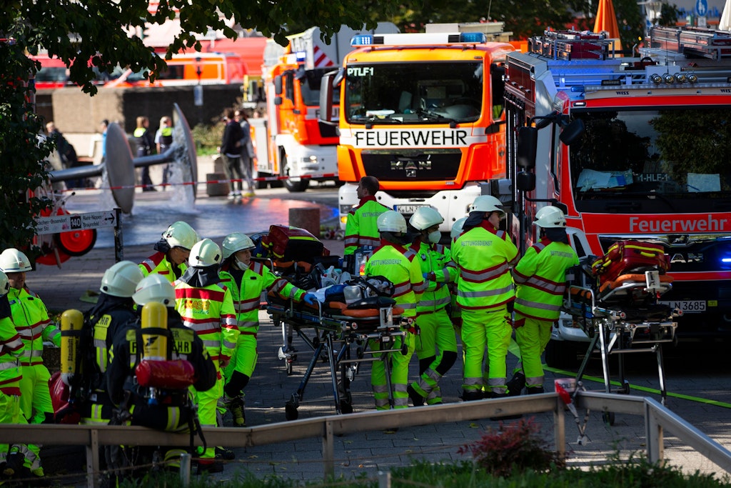 Rettungskräfte stehen während der Löscharbeiten am U-Bahnhof Ebertplatz in Köln.