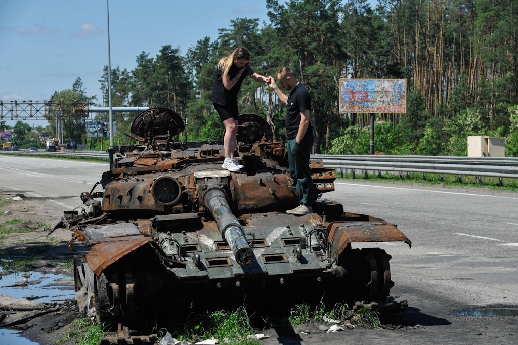 (Archivbild) Menschen inspizieren einen zerstörten Panzer der russischen Armee westlich von Kiew. Ein solches Wrack soll jetzt als Protest gegen den Krieg vor der russischen Botschaft in Berlin-Mitte aufgestellt werden. 