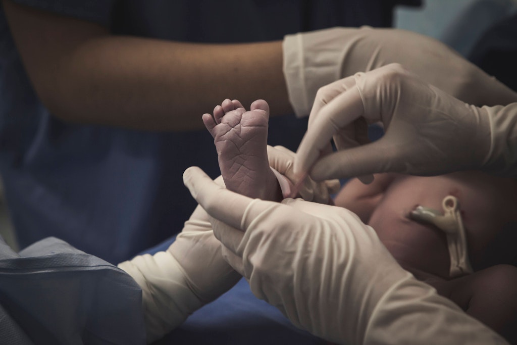 Ein Neugeborenes in der Hand einer Krankenschwester im Krankenhaus.