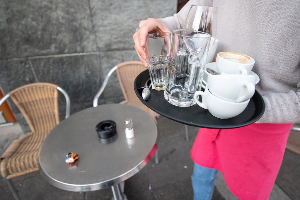 Ein Kellner räumt einen Tisch in einem Restaurant ab. Mehr als ein Drittel der Beschäftigten im Gastgewerbe kann sich laut einer Umfrage einen längeren Verbleib in der Branche nicht vorstellen. 