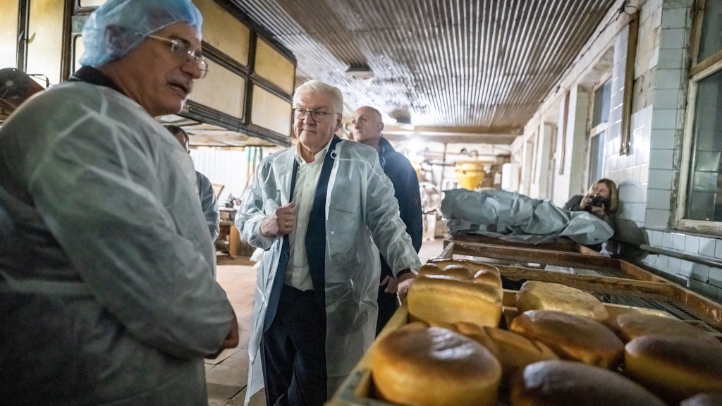 Bundespräsident Frank-Walter Steinmeier spricht nach dem Luftalarm mit Produktionsleiter Oleksander Jermolenko in der Brotfabrik von Korjukiwka.