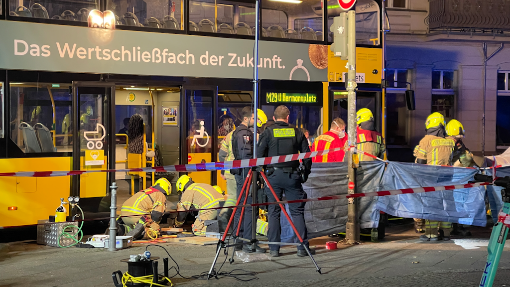 Feuerwehrmänner befreien einen Fußgänger, der in Kreuzberg unter einem Bus geraten war.