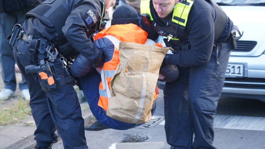 Zwei Polizisten tragen einen Demonstranten von der Fahrbahn. Für die Polizei fielen in diesem Jahr bisher 131.685 Arbeitsstunden in Zusammenhang mit den Blockaden an.