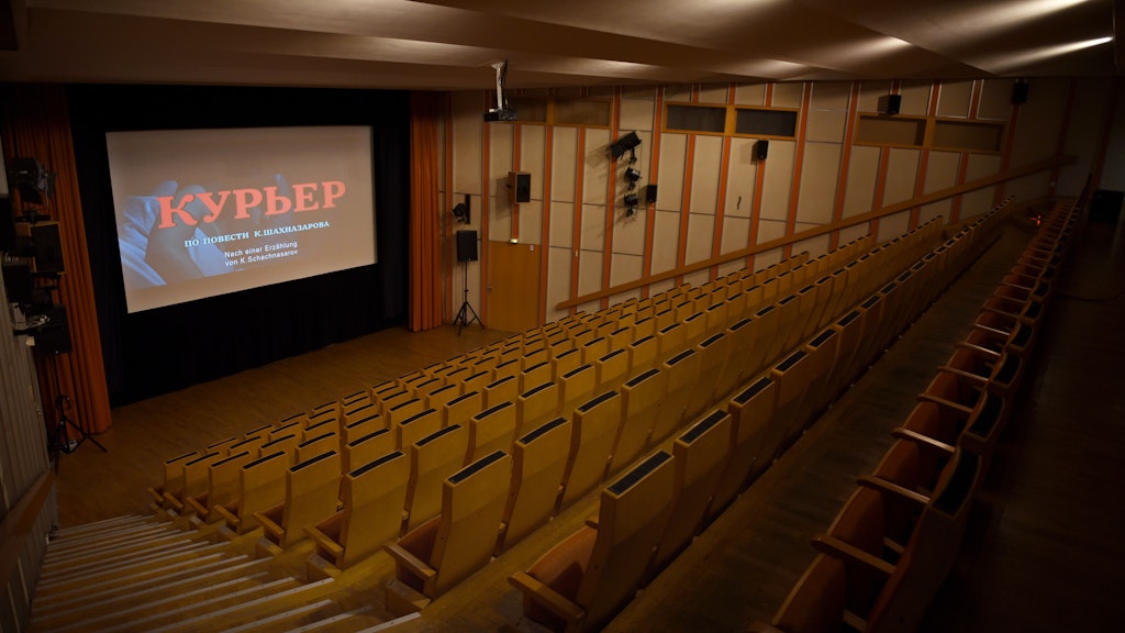Auf der Leinwand ist der Abspann des Films „Der Bote“ von Karen Schachnasarow zu sehen, dem das Russische Haus eine Retrospektive widmete, der aber in der Öffentlichkeit den russischen Krieg gegen die Ukraine rechtfertigt und Putin-Gegner in Konzentrationslager sperren will.