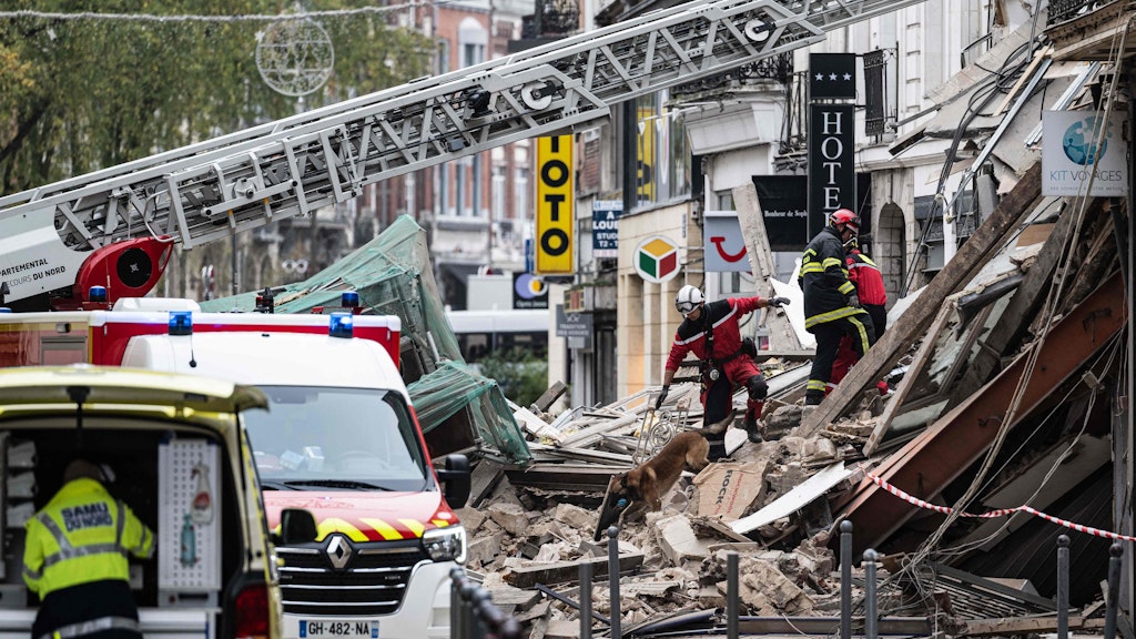 Feuerwehrleute inspizieren ein eingestürztes Gebäude in Lille, während sie nach Opfern suchen.