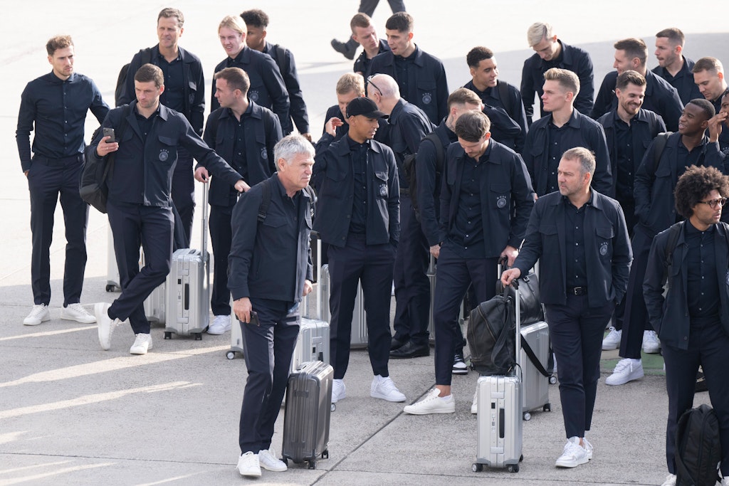 Bundestrainer Hansi Flick (2. v. r.) wartet mit der Nationalelf auf dem Rollfeld am Flughafen Frankfurt. Alle sind bereit für den Abflug zur WM. 
