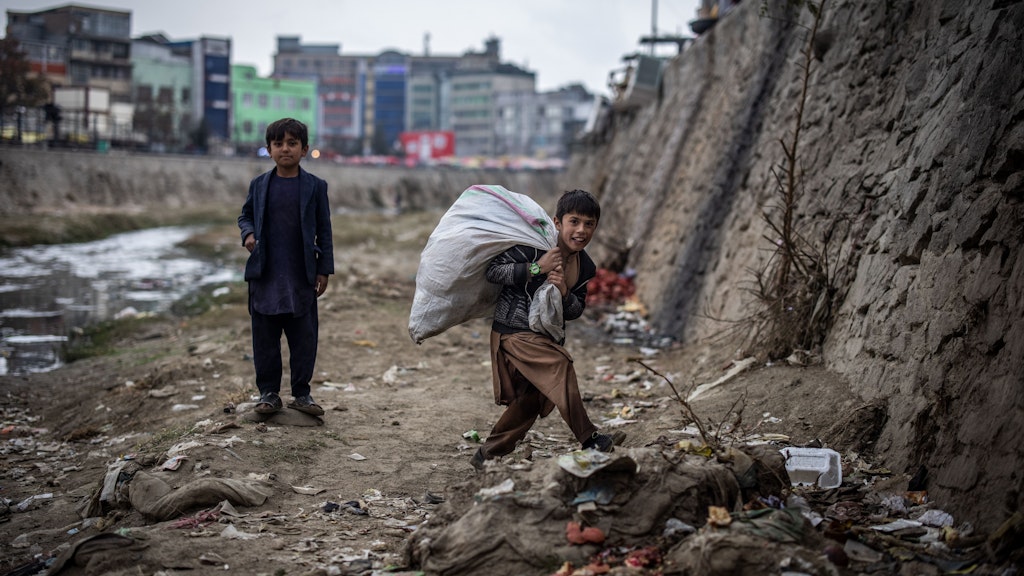 Kabul: Zwei Jungen suchen am Ufer des Kabul-Flusses nach Plastikflaschen, die sie für wenig Geld an ein Recyclingzentrum verkaufen können. Viele Kinder in Afghanistan müssen arbeiten, um zum Familieneinkommen beizutragen. 