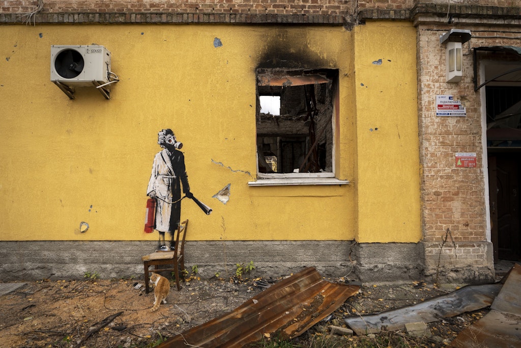 Dieses undatierte Handout-Foto hat der Streetart-Künstler Banksy über eine Agentur an die britische Nachrichtenagentur Press Association gegeben. Auf der gelben Wand eines kriegszerstörten Hauses ist eine Person zu sehen, die eine Gasmaske und einen Feuerlöscher trägt. Banksy hat sich nun auf Instagram zu einer ganzen Reihe von Werken in der Ukraine bekennt.