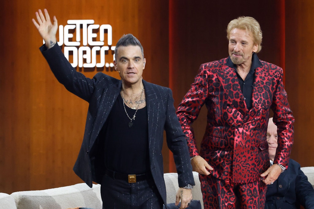 Zwei Männer in schicken Anzügen: Der britische Popstar Robbie Williams verabschiedet sich bei der ZDF-Show "Wetten, dass..?" vom Publikum. Thomas Gottschalk moderierte am Sonnabend in einem Anzug in rot-schimmerndem Leo-Look. 